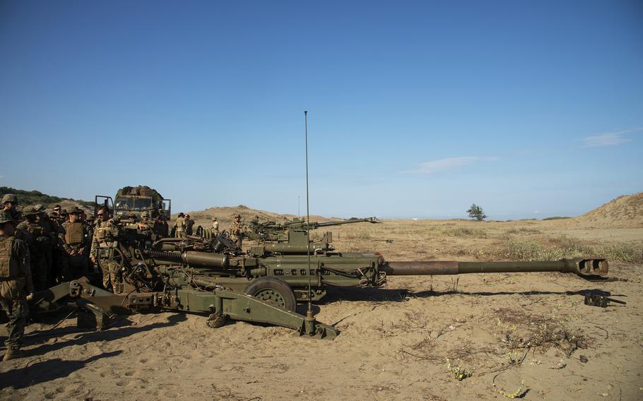 A soldier with the 7th Field Artillery Regiment speaks to Marines and sailors about the M-777 howitzer during a Balikatan drill at the La Paz Sand Dunes in Laoag, Philippines, May 6, 2024.