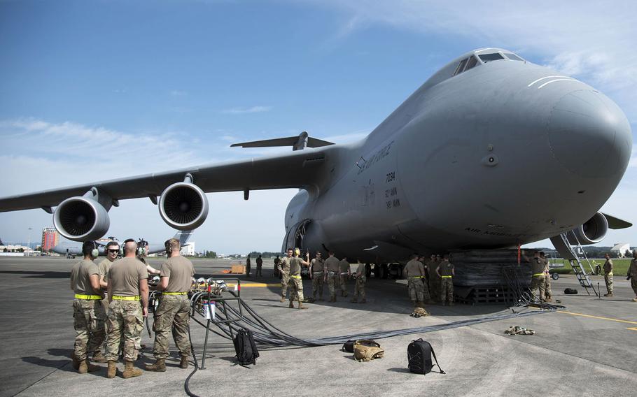 Airmen take part in aircraft recovery training next to a C-5M Super Galaxy visiting Yokota Air Base, Japan, Sept. 13, 2021.  