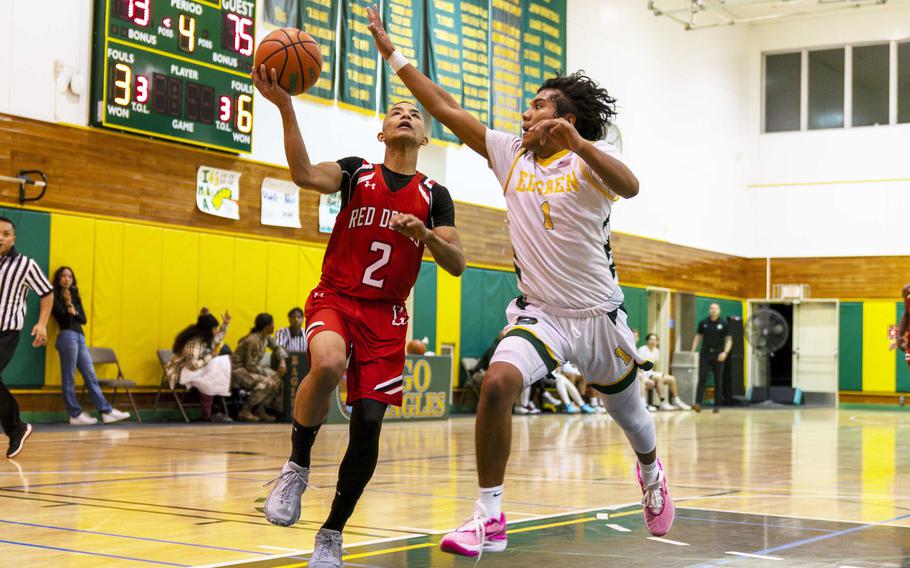 Nile C. Kinnick's Vance Lewis drives to the basket against Robert D. Edgren's Micah Magat during Friday's DODEA-Japan boys basketball game. The Red Devils won 80-78.