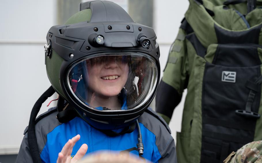 A student tries on an explosive ordnance disposal helmet during the Student Engagement and Career Day event at Joint Base McGuire-Dix-Lakehurst, N.J., Friday, April 19, 2024. 
