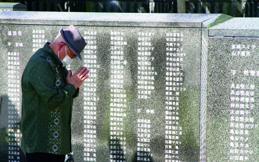 An Okinawan mourns for lost relatives during the Irei no Hi ceremony at Okinawa Peace Memorial Park in Naha, Okinawa, June 23, 2017.