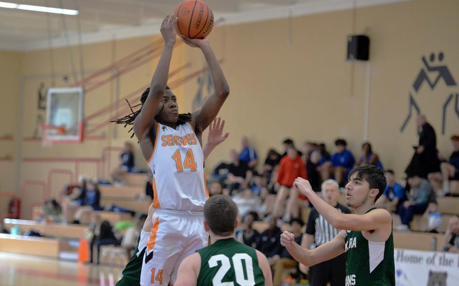 In a D-III game on opening day of the DODEA-Europe basketball finals in Baumholder, Germany, Spangdahlem’s Messiah Smith shots over Ankara’s Andrew Lofay, left, and Adeeb Ahang. The Sentinels won 42-2.