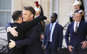 Macron and Zelenskyy embrace.