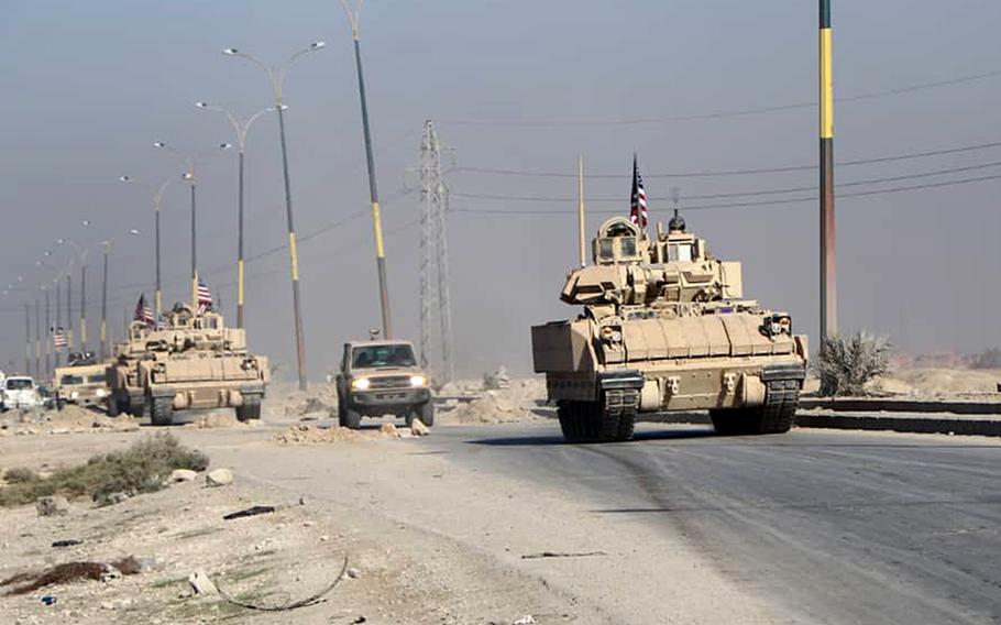 American troops make their way along a road near the al-Sinaa prison in Hassakeh, Syria. An attack on the prison by Islamic State militants ended Sunday after 10 days.