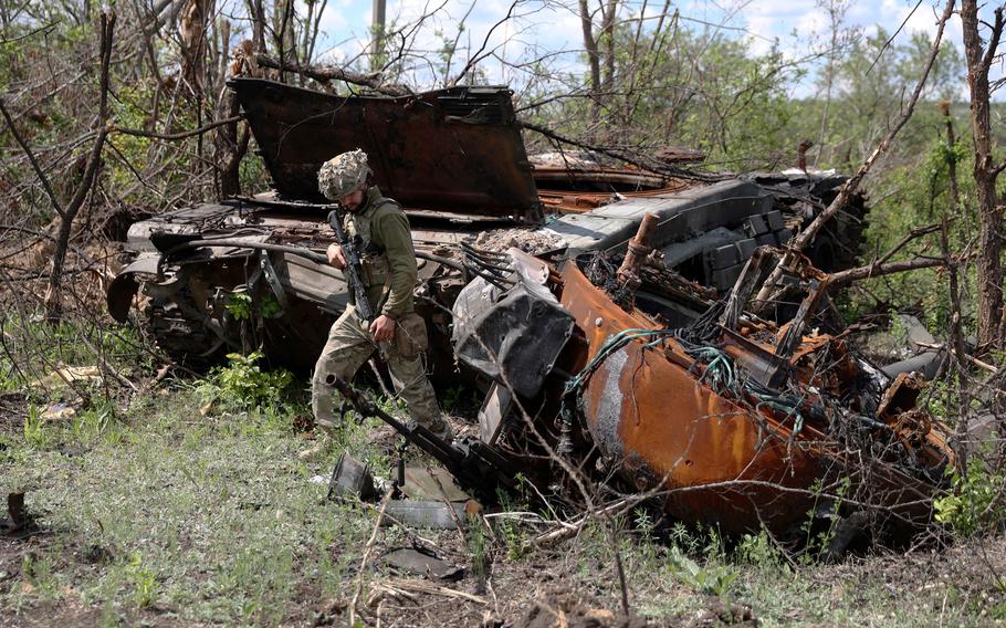 A Ukrainian serviceman inspects a destroyed Russian tank at an abandoned Russian position near the village of Bilogorivka, not far from Lysychansk, Lugansk region, on June 17, 2022.