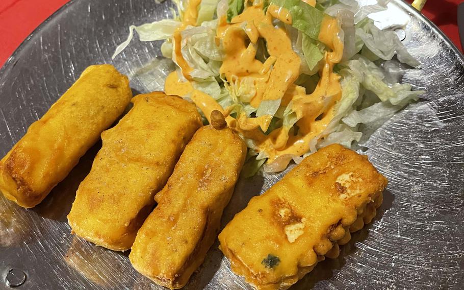 The paneer pakora, homemade cheese coated with chickpea flour and fried, at Ganesha in Weiden, Germany, Dec. 21, 2021. The appetizer is complemented with a side salad and well-suited to sharing.