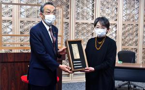 Noriko Kawarai, right, receives a relic from the Battle of Iwo Jima that belonged to her uncle, Morihiro Murota, from Mayor Shin Sato at Kanuma City Hall, Dec. 20, 2022.