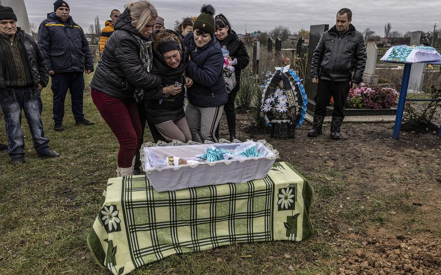 Maria Kamianetska, 36, is held by her mother, Tetiana Svystunova, left, and her sister, Lyuba, as she mourns her baby son, Serhii Podlianov, on Nov. 24, 2022, in Novosolone, Ukraine. 