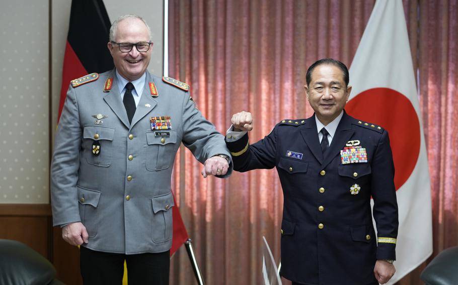 Gen. Eberhard Zorn, left, chief of Defense of the German Armed Forces, and Gen. Koji Yamazaki, chief of Staff, Joint Staff of the Japan Self-Defense Forces, pose for a photo before their talk at the Ministry of Defense in Tokyo, Friday, Nov. 5, 2021. 