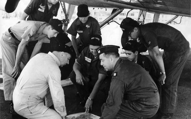 [PUBLISHED CAPTION: Crew members and volunteer "scanners' who flew a six-hour search mission Sunday for the missing Flying Tiger Super Constellation talk over their mission at Clark AB, P.I. They are (kneeling, from left) Capt. Theodore Stewart, 405th Fighter Wing pilot; A/1C James C. Johnson, crew chief; A/3C Lawrence L. Clatchey, and Capt. Lawrence R. Brosy, copilot. Others are (from left) A/2C Robert L. Jones, A/3C Dennis Jones, A/3C David K. Crausby and A/3C Edward M. Raquel, assistant crew chief. Pacific Stars and Stripes reporter S/Sgt. Robert G. Fisher of the Philippines Bureau accompanied the search mis-mission [sic]. 03/20/1962]; Crew members and volunteer "scanners" talk over the six-hour search and rescue mission searching for the Flying Tiger Airline Super Constellation that disappeared over the Western Pacific Ocean March 16, 1962. The missing plane - which was chartered by the U.S. Army - was transporting 96 military passengers and had 9 crew members on board. The crew pictured here after their return to Clark Air Base are (kneeling, from left) Capt. Theodore Stewart, 405th Fighter Wing pilot; Airman First Class James C. Johnson, crew chief; Airman Third Class Lawrence L. Clatchey, and Capt. Lawrence R. Brosy, copilot. Others are (from left) Airman Second Class Robert L. Jones, Airman Third Class Dennis Jones, Airman Third Class David K. Crausby and Airman Third Class Edward M. Raquel, assistant crew chief. Pacific Stars and Stripes reporter Staff Sgt. Robert G. Fisher (not pictured) of the Philippines Bureau accompanied the search mission. [cg]