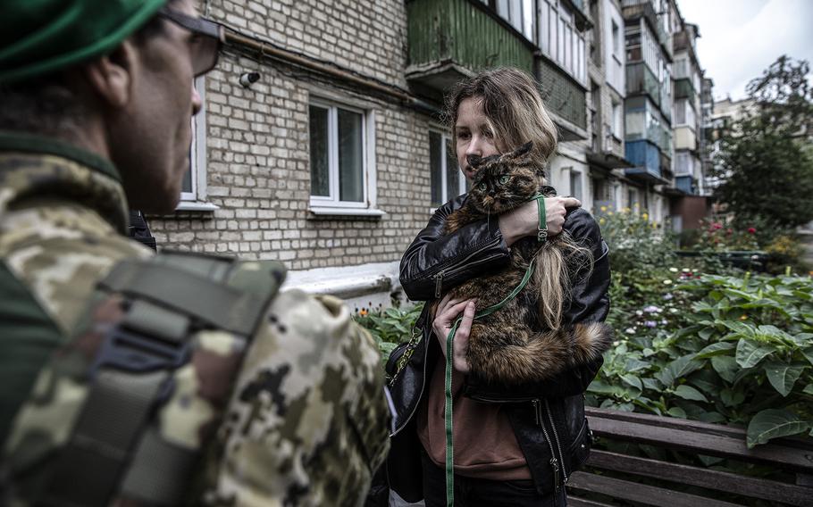 Liza Udovik, 26. holds her cat named Masato as she speaks to a volunteer that is helping her and other residents that evacuated their home in Kupiansk, Ukraine, on Sept. 16, 2022. 