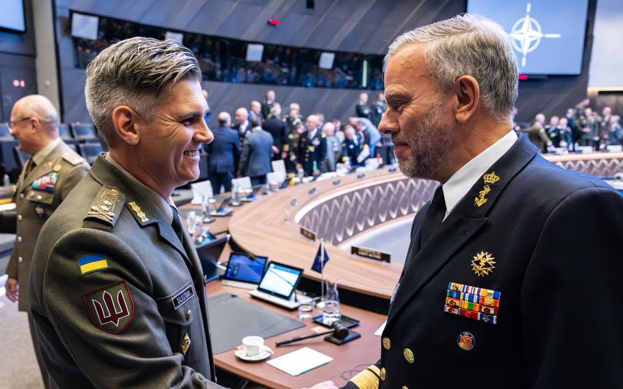 Dutch Adm. Rob Bauer, chairman of the NATO Military Committee, right, greets Ukrainian Maj. Gen. Serhii Salkutsan at a NATO meeting in Brussels on May 10, 2023. Bauer said the alliance will remain staunch in its support for Ukraine in the war against Russia.