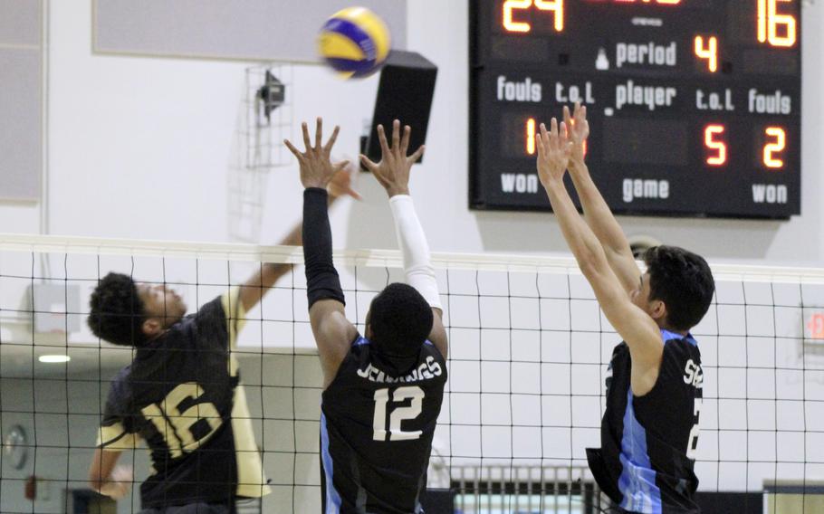 Humphreys' Kaleb Jett tries to send the ball past Osan's T'zuriel Jennings and M.J. Seibert during Saturday's DODEA-Korea boys volleyball match. The Cougars won in five sets.