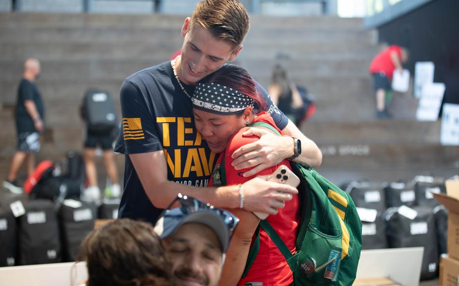 Navy service member hugging a Marine Corps service member.