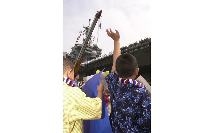 USS Kitty Hawk family members wave as the ship returns from Operation Iraqi Freedom.