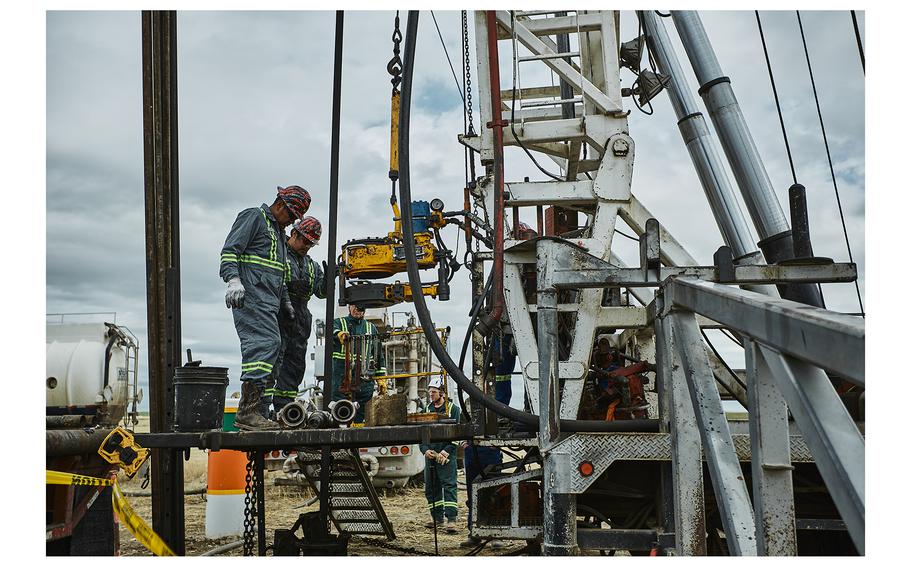 Workers operate a drilling rig while plugging an abandoned oil well north of Shelby, Mont.
