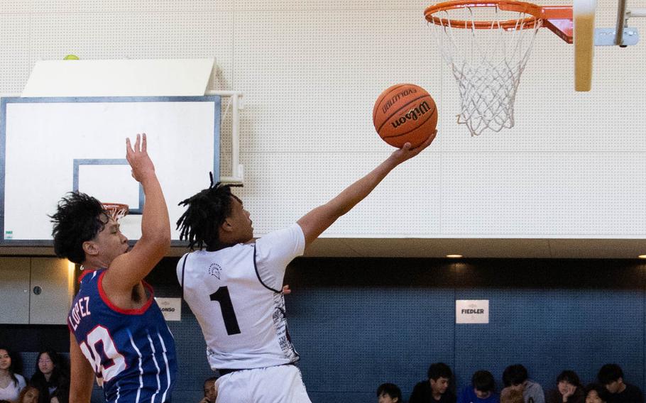 Zama's Ayden Helton drives for a layup against Okkodo's Jude Lopez. The Trojans rallied for a 32-29 win.