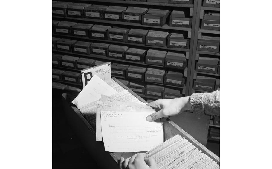 An ITS investigator searches through record cards.