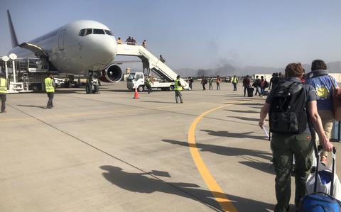 People board a plane chartered by the U.S. government at the airport in Kabul as they prepare to evacuate Afghanistan, Aug. 15, 2021.