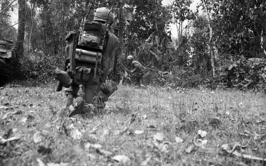 Marines of Alpha Company, 1st Battalion, 9th Marines fire at North Vietnamese Army soldiers. A claymore mine explosion minutes earlier cost the life of the platoon sergeant of Alpha Company.