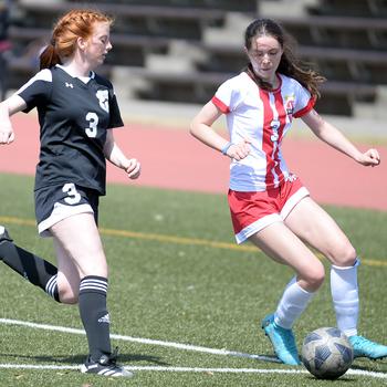 Nile C. Kinnick's Bridget Pidgeon looks to pass the ball as Zama's Avery Pilch gives chase during Saturday's DODEA-Japan soccer match. The Red Devils won 2-0.