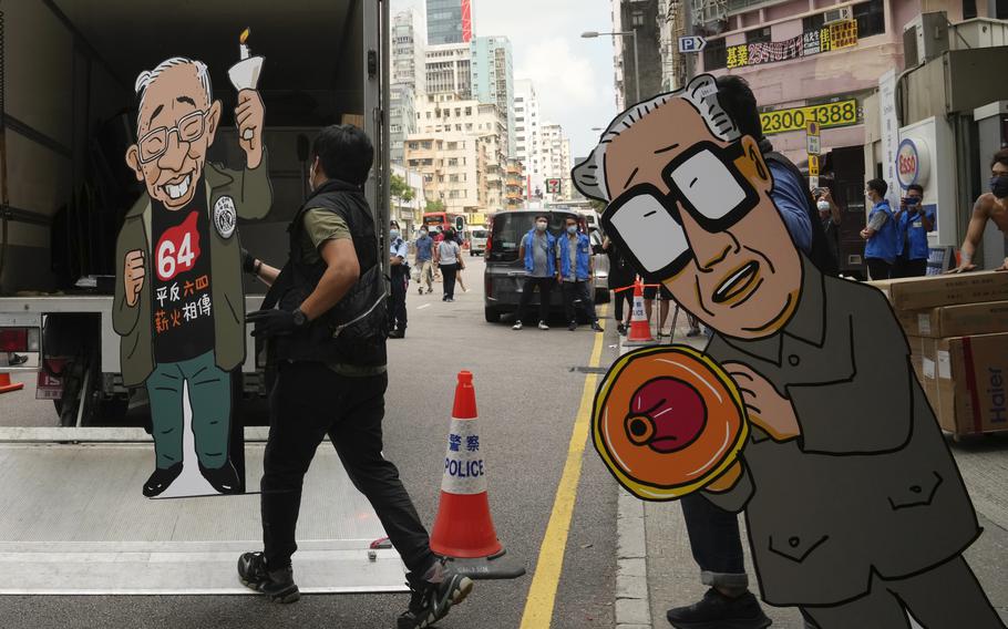 Police officers take away cardboards featuring the images of Former Chinese Premier Zhao Ziyang, right, and pro-democracy activist Szeto Wah from the June 4th Museum in Hong Kong, on Thursday, Sept. 9, 2021. A dozen Hong Kong pro-democracy activists pleaded guilty on Thursday to participating and inciting others to take part in last year's unauthorized candlelight vigil to mark the bloody Tiananmen Square crackdown.