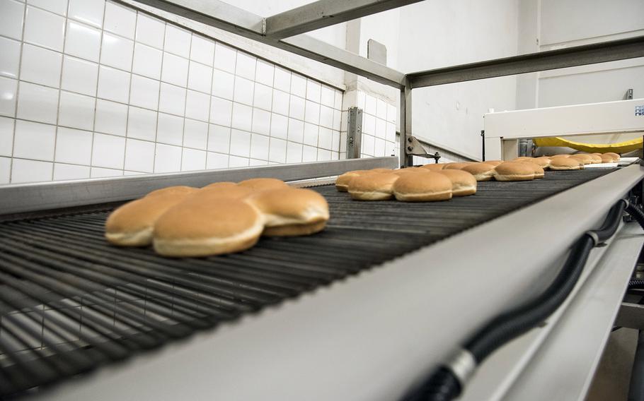 Freshly baked buns move on a conveyor belt at the Yokota Bakery Plant on Yokota Air Base, Japan, Tuesday, April 19, 2022.