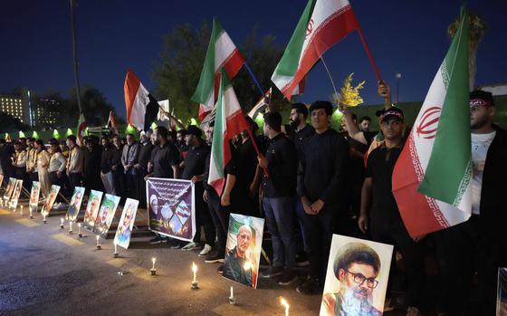 Protesters gather in front of the Iranian embassy carrying candles and Iranian flags during a stand honoring the Iranian armed forces generals, nuclear scientists, and their family members who were killed in Israeli strikes, in Baghdad, Iraq, Saturday, June 28, 2025. (AP Photo/Hadi Mizban)