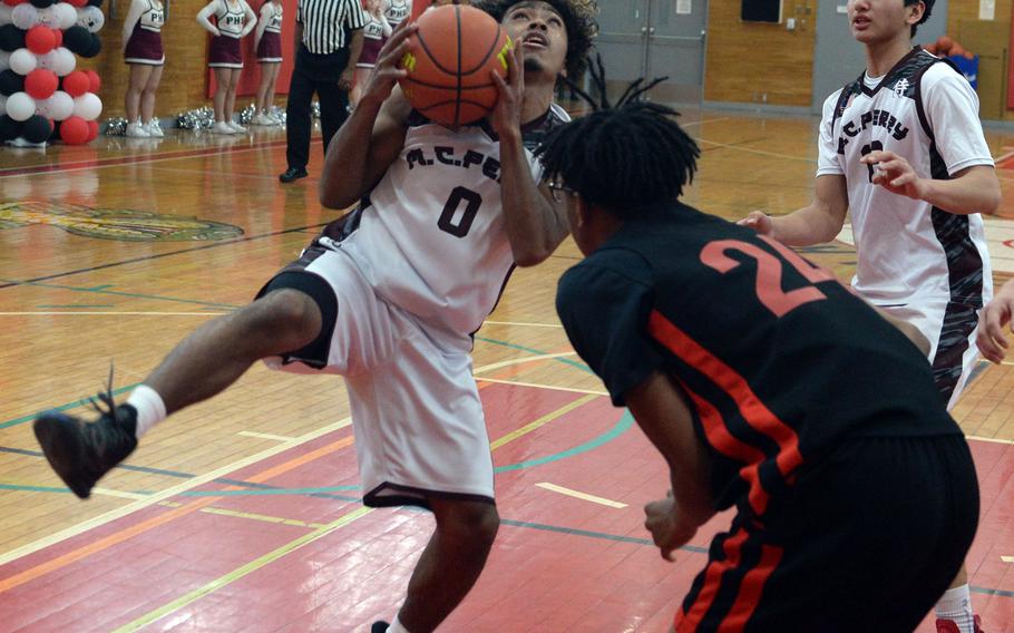 Matthew C. Perry's Denzel Gray comes down with a rebound in front of E.J. King's Keith Lombard during Saturday's DODEA-Japan boys basketball game. The Samurai won 62-55.