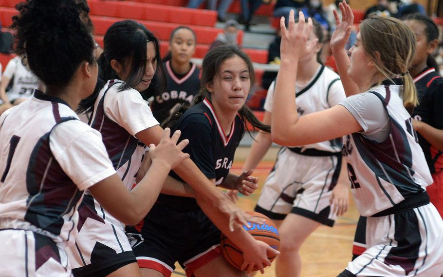 E.J. King's Maliwan Schinker is surrounded by Matthew C. Perry defenders during Saturday's DODEA-Japan basketball game. The Cobras won 56-9.