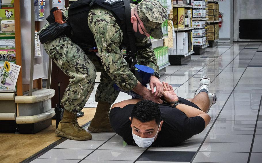 Petty Officer 1st Class James Eggers detains an actor playing an armed suspect during the Citadel Pacific exercise inside the exchange at Yokosuka Naval Base, Japan, July 20, 2021.