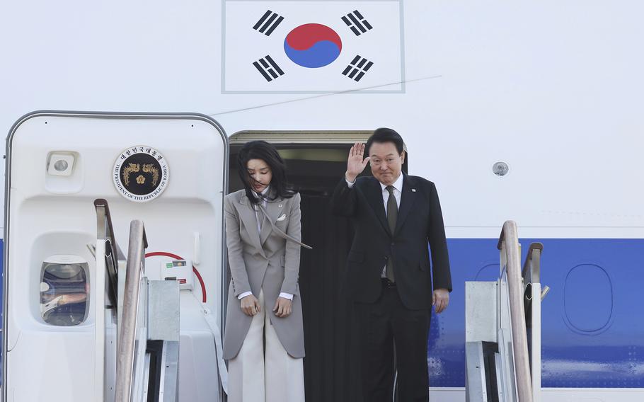 South Korean President Yoon Suk Yeol, right, waves as his wife Kim Keon Hee bows before departing for Japan at the Seoul military airport in Seongnam, South Korea, Thursday, March 16, 2023.