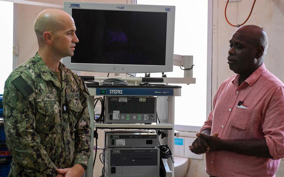 Cmdr. Gregory Hall, surgical planner on the USNS Mercy, and Dr. Rooney Jagilly, chief of surgery and acting CEO of the National Referral Hospital in Honiara, Solomon Islands, stand beside a laparoscopy tower donated by the U.S. Defense Department during the Pacific Partnership mission in early December 2023.