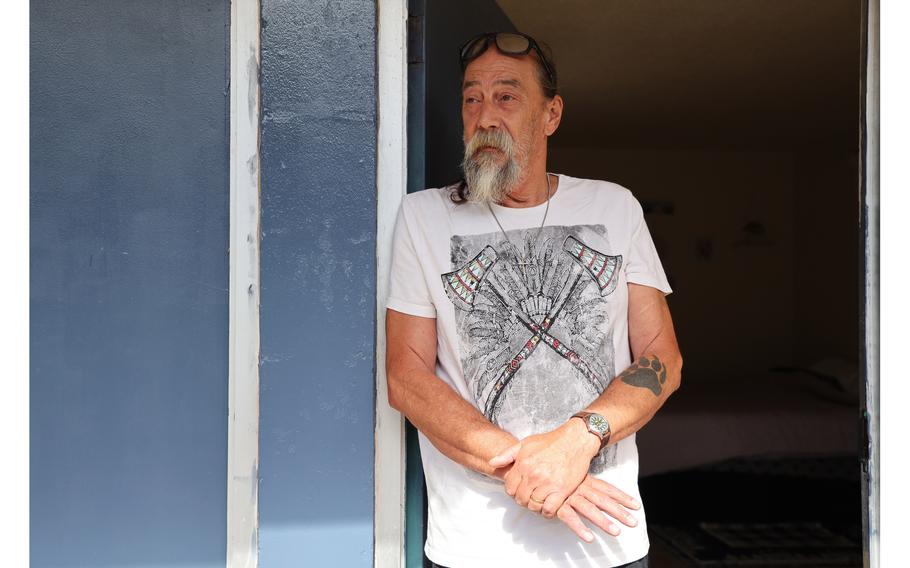 A man leaning against a door frame