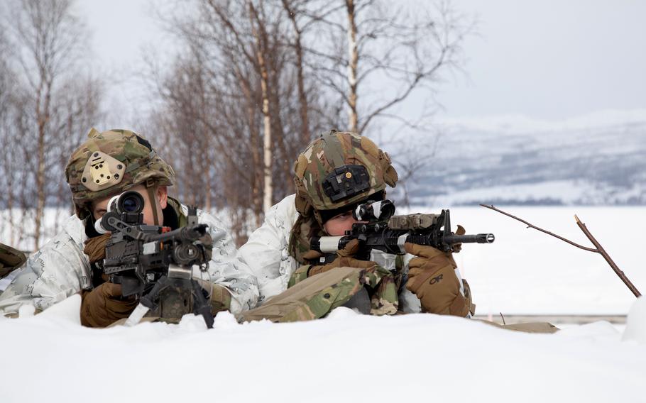 U.S. Army Spc. Andrew Hayes, left, and Spc. Christopher Bryant, infantrymen in the 11th Airborne Division, provide security after a parachute jump near Bardufoss, Norway, March 18, 2024. 