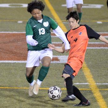 Nile C. Kinnick’s Luis Galloway boots the ball past Kubasaki’s Ayden Rodrigues during the Dragons’ 4-0 Perry Cup win over the Red Devils.