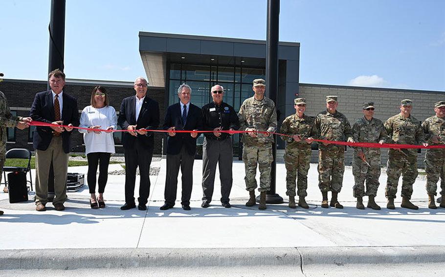 Maj. Gen. Al Dohrmann, adjutant general for the N.D. National Guard (left of flag pole) leads a group of dignitaries during a ribbon cutting ceremony celebrating the dedication of the N.D. National Guard’s Fargo Readiness Center, Fargo, N.D., August 24, 2021. From left, Shawn Dobberstein, Executive Director at Fargo Airport Authority; Mary Chrisy, representative for Congressman Kelly Armstrong; U.S. Sen. Kevin Cramer; U.S. Sen. John Hoeven; Delton Steele, honorary commander for the N.D. National Guard and chair of the N.D. Employer Support of the Guard and Reserve (ESGR); Dohrmann, Brig. Gen. Jackie Huber, deputy adjutant general, N.D. National Guard, Brig. Gen. Leo Ryan, commander, N.D Army National Guard; Col. Paul Harron, Command Sgt. Maj. Eric Binstock, senior enlisted leader, N.D. National Guard; and Command Sgt. Maj. Derek Heck, state command sergeant major for the N.D. Army National Guard.