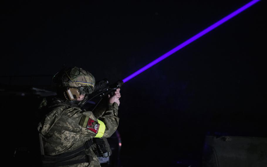 A drone hunter unit commander aims a thermal vision sensor into the sky.