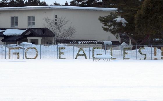A leftover sign from the football season remains embedded in the fence, partly covered by nearly a foot of snow at Robert D. Edgren's Eagles Field, used for soccer in the spring.