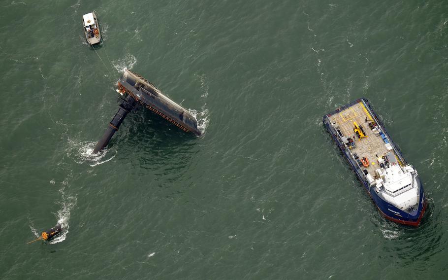 Rescue boats are seen next to the capsized lift boat Seacor Power, left, seven miles off the coast of Louisiana in the Gulf of Mexico on April 18, 2021.