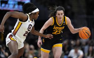 Iowa guard Caitlin Clark (22) drives up court past South Carolina guard Raven Johnson, left, during the first half of the Final Four college basketball championship game in the women's NCAA Tournament, Sunday, April 7, 2024, in Cleveland. (AP Photo/Carolyn Kaster)