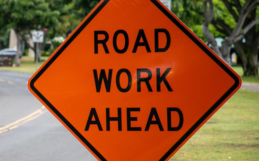 A sign reading “road work ahead” is visible on a street.
