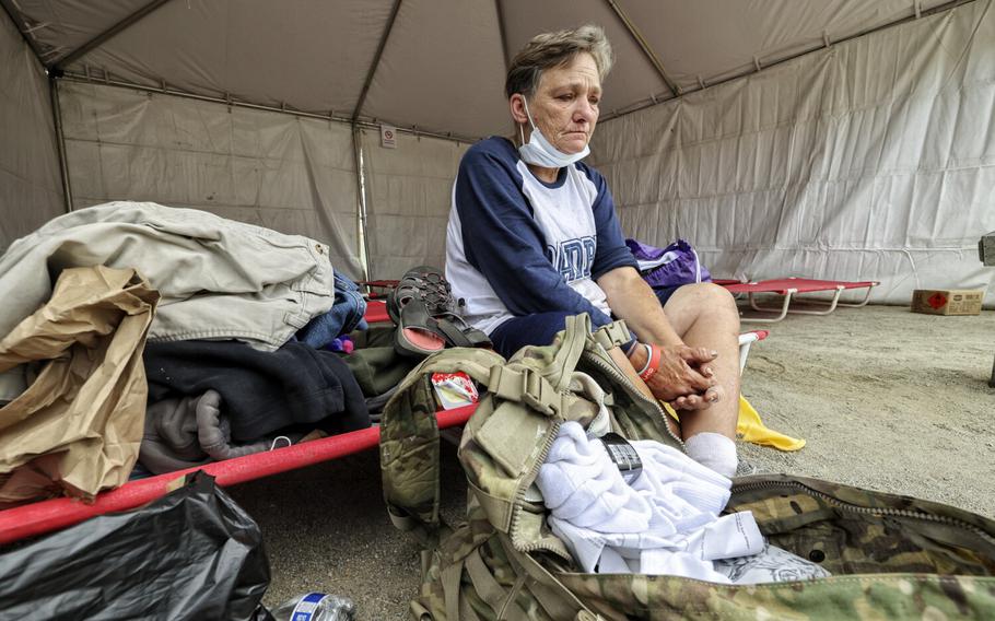 Sitting in her cot in the tent area where she will spend the night, Tammy Seymore takes a moment to remember her recently deceased husband of 23 years who was a veteran, during the Veterans Village of San Diego 35th Stand Down event held at Roosevelt Middle School on Friday, July 29, 2022 in San Diego, CA.