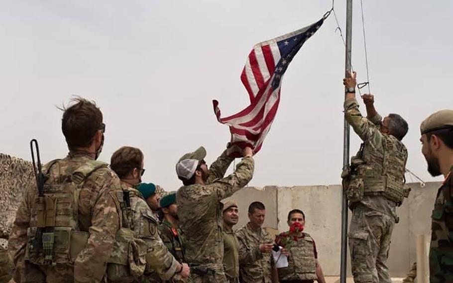 In this May 2, 2021 file photo, a U.S. flag is lowered as American and Afghan soldiers attend a handover ceremony from the U.S. Army to the Afghan National Army, at Camp Anthonic, in Helmand province, southern Afghanistan. 