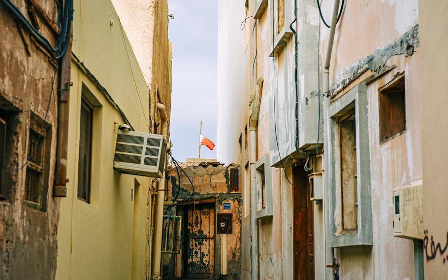 A Bahraini flag waves in the distance in the the town of Muharraq. The souk there features a blend of architectural styles and is near the Pearling Path, a UNESCO World Heritage site.