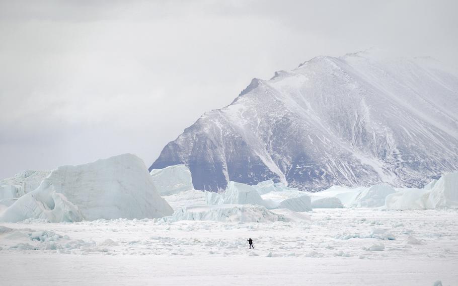 A skier passes icebergs while crossing the sea ice. Climate change imperils the traditional ways of life in Qaanaaq.