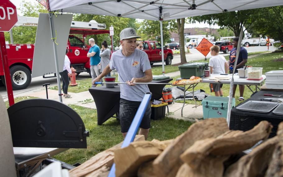 Brian Rock, of Elevated Pie Co. in Merrillville, Ind., makes free pizzas for residents after driving his mobile pizza oven truck to Darien, Ill. June 21, as neighbors and utility workers cleaned up damage from a tornado.