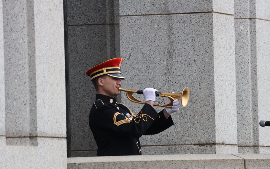 Bugler Sgt 1st Class Jeffrey Northman plays taps at the World War II Memorial on the National Mall in Washington, D.C., on Memorial Day, May 29, 2023.
