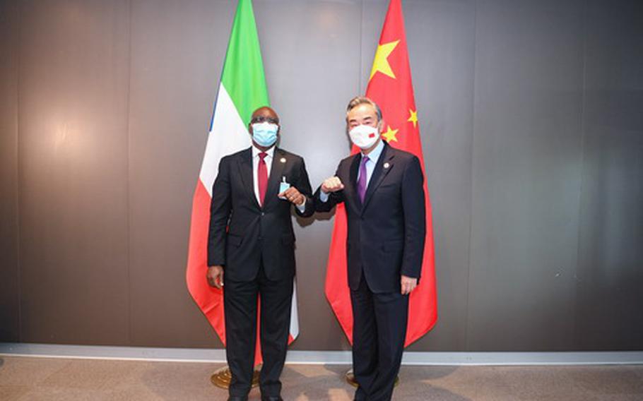 Chinese Foreign Minister Wang Yi, right, met with Equatorial Guinean Foreign Minister Simeon Oyono Esono Angue the Forum on China-Africa Cooperation in Dakar, Senegal, Nov. 30, 2021. China has its eyes on the small western African country for a new military base, which would give Beijing a naval foothold in the Atlantic Ocean.