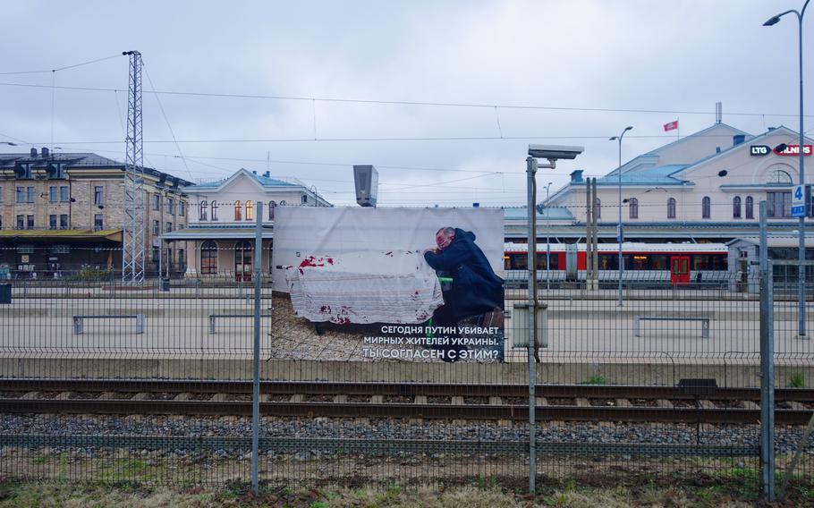 Train passengers traveling between Moscow and Kaliningrad pass through the central railway station in Vilnius, Lithuania, where they are greeted with a display of graphic photos from Russia’s war in Ukraine. The photo reads: “Today Putin is killing peaceful civilians in Ukraine. Do you agree with this?”